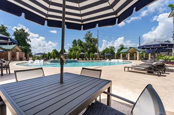 Table with chairs and umbrella by the pool